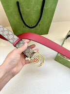 Gucci belt close-up of buckle: gray GG monogram strap with red leather strap section