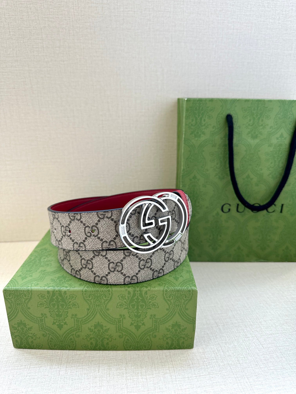 Gucci belt on display: gray GG monogram strap with red edge and silver-tone GG buckle
