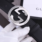 Black leather belt with silver-toned GG-style buckle, patterned edge detailing