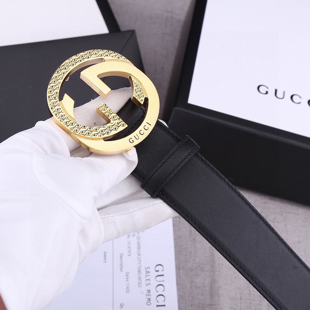 Black leather belt with gold GG-style buckle and black strap with seam stitching