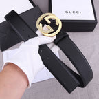 Black leather belt with gold round buckle, visible keeper loop and punched sizing holes