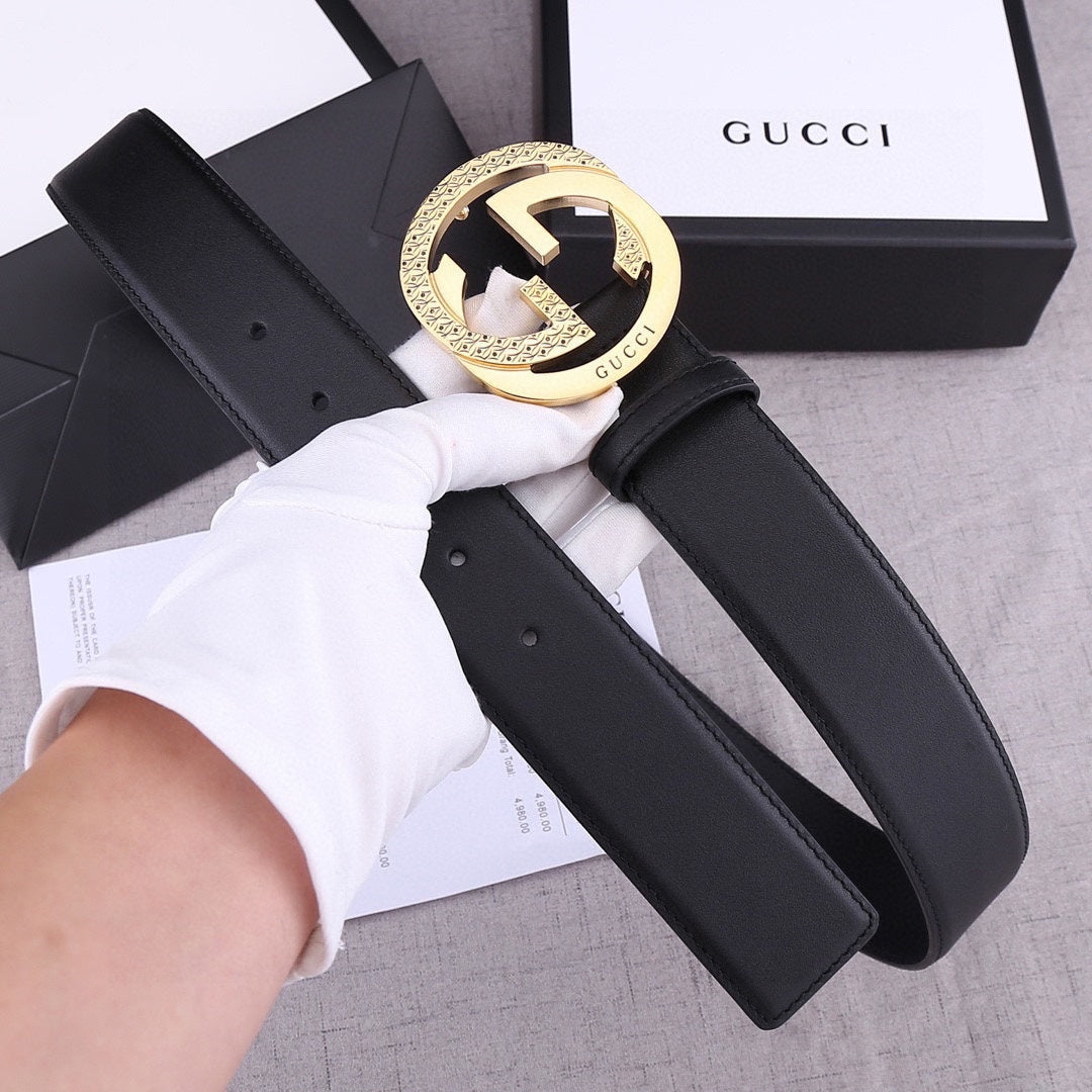 Black leather belt with gold round buckle, visible keeper loop and punched sizing holes