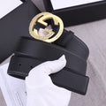 Black leather belt with gold GG-style round buckle and embossed signature detail