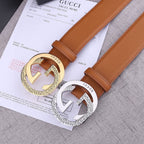 Tan leather Gucci belts with gold and silver round GG buckles on paperwork