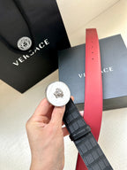 Versace belt detail with black strap, round medallion buckle and red lining