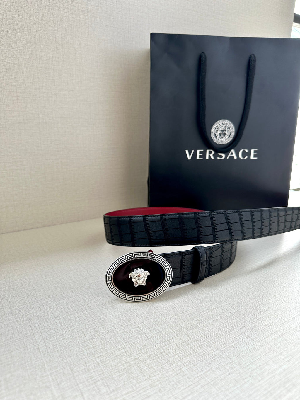 Versace belt coiled: black textured strap with round gold medallion buckle