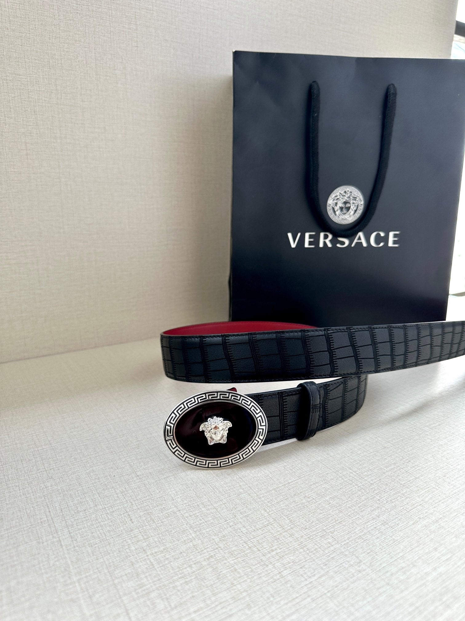 Versace belt coiled: black textured strap with round gold medallion buckle