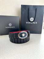 Versace belt on display: black textured strap with round gold medallion buckle