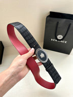 Versace belt held up: black textured strap, round medallion buckle, red underside