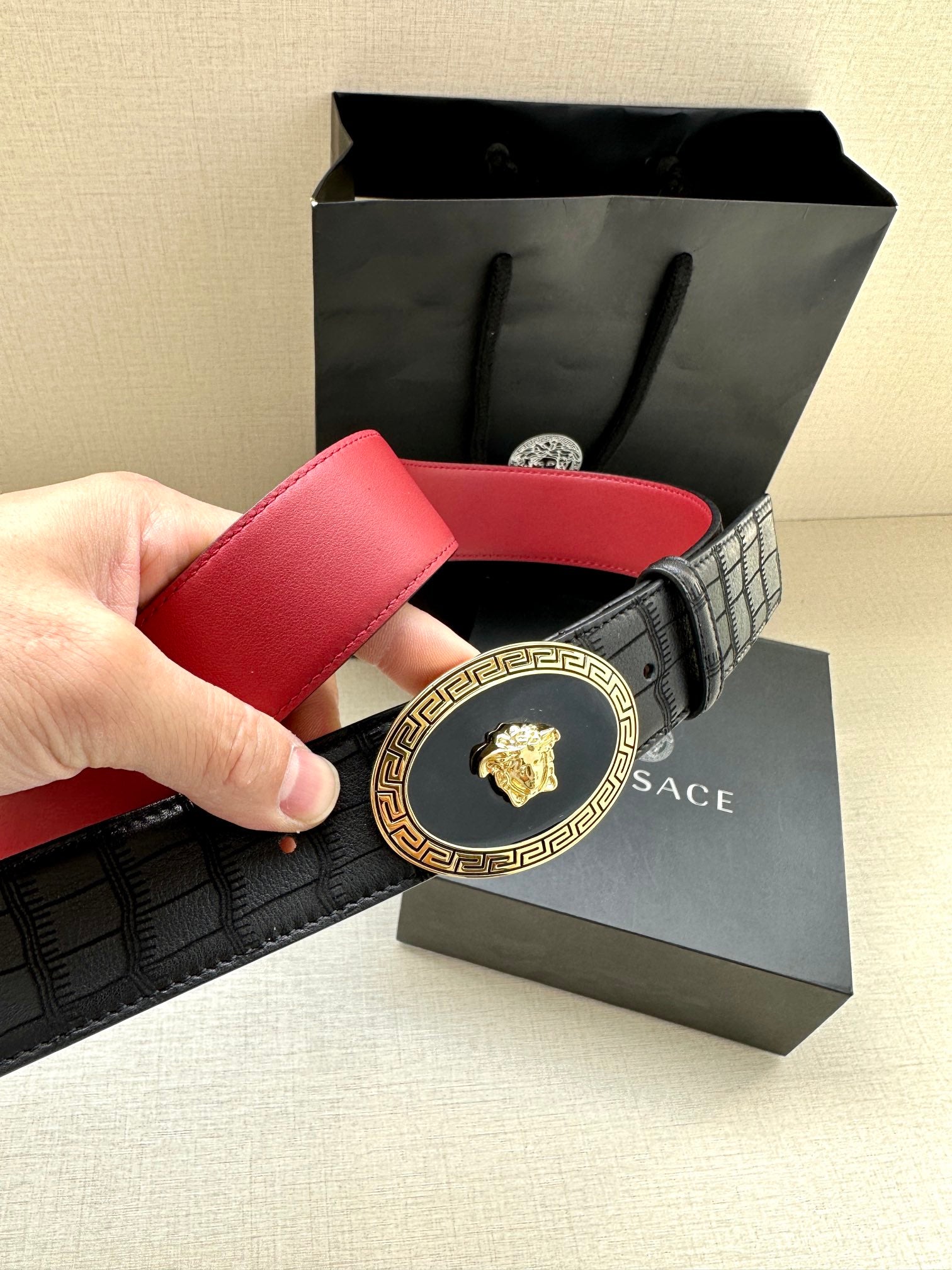 Versace belt with black embossed texture, gold baroque medallion buckle and red strap