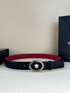 Versace belt with black textured strap and round gold medallion buckle on red back