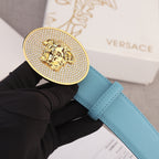Light blue belt with round gold-tone rhinestone medallion buckle and lion head emblem
