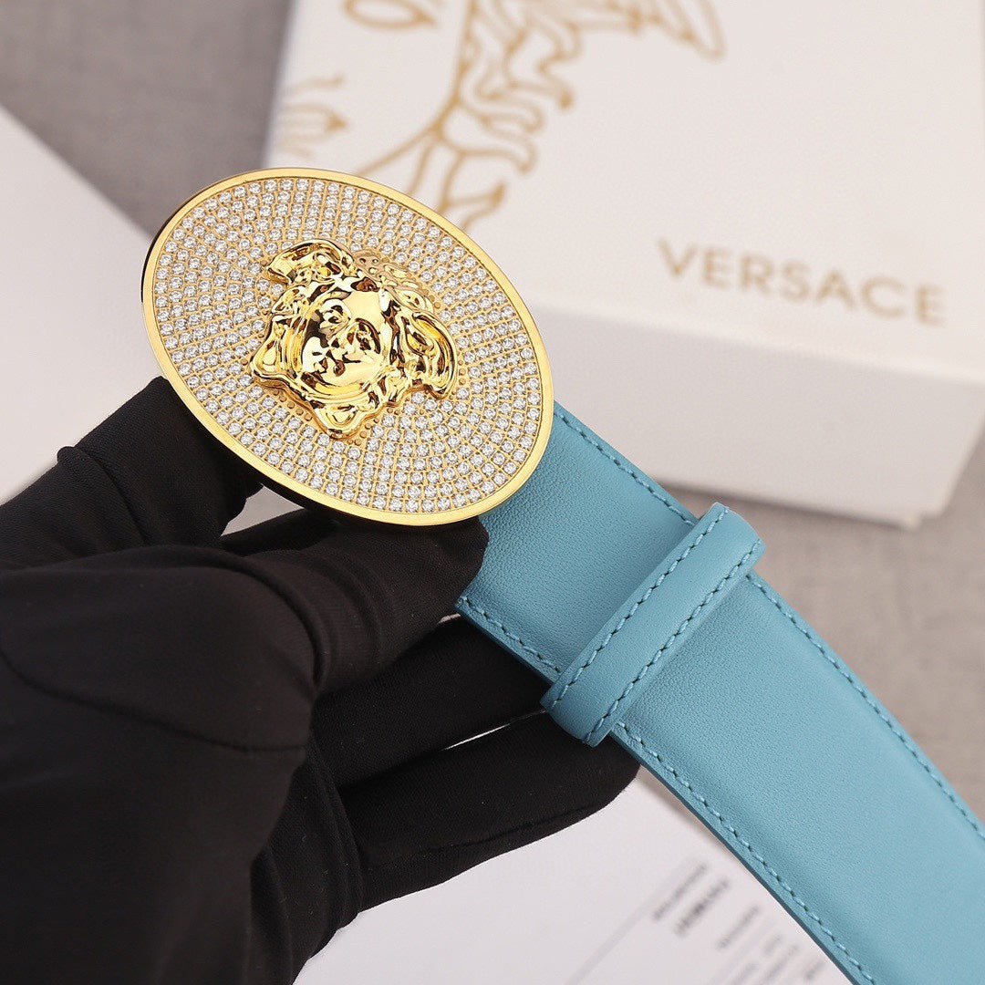 Light blue belt with round gold-tone rhinestone medallion buckle and lion head emblem