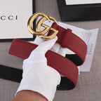 Red leather Gucci belt with gold double-G buckle and black underside
