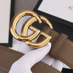 Brown leather belt close-up of gold-tone GG buckle and leather strap