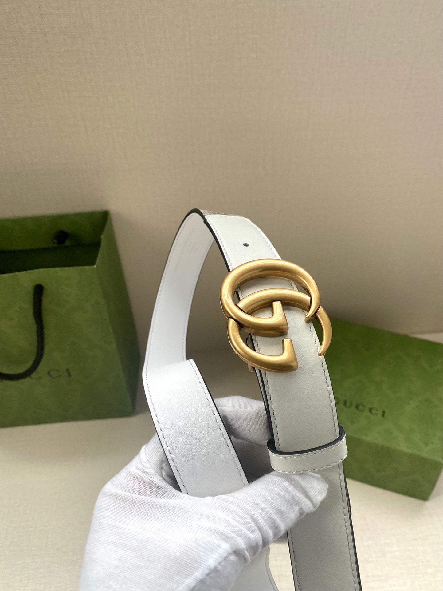 White leather belt with gold-tone double G buckle and punched holes