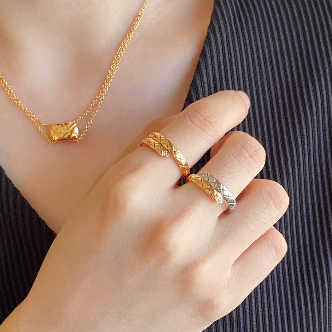 Gold-tone ring with lattice design and matching necklace on a hand