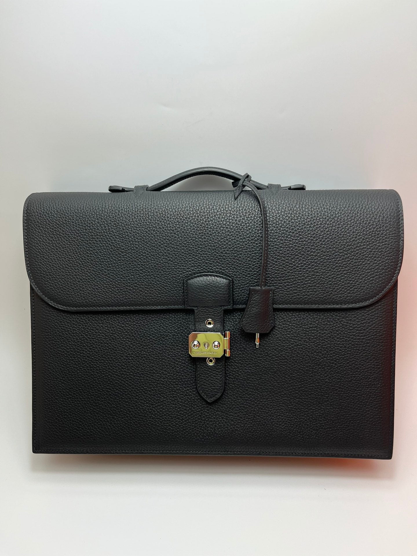 Dark gray leather satchel bag with front flap and metal clasp