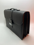 Dark gray leather satchel bag angled view with front flap and side strap