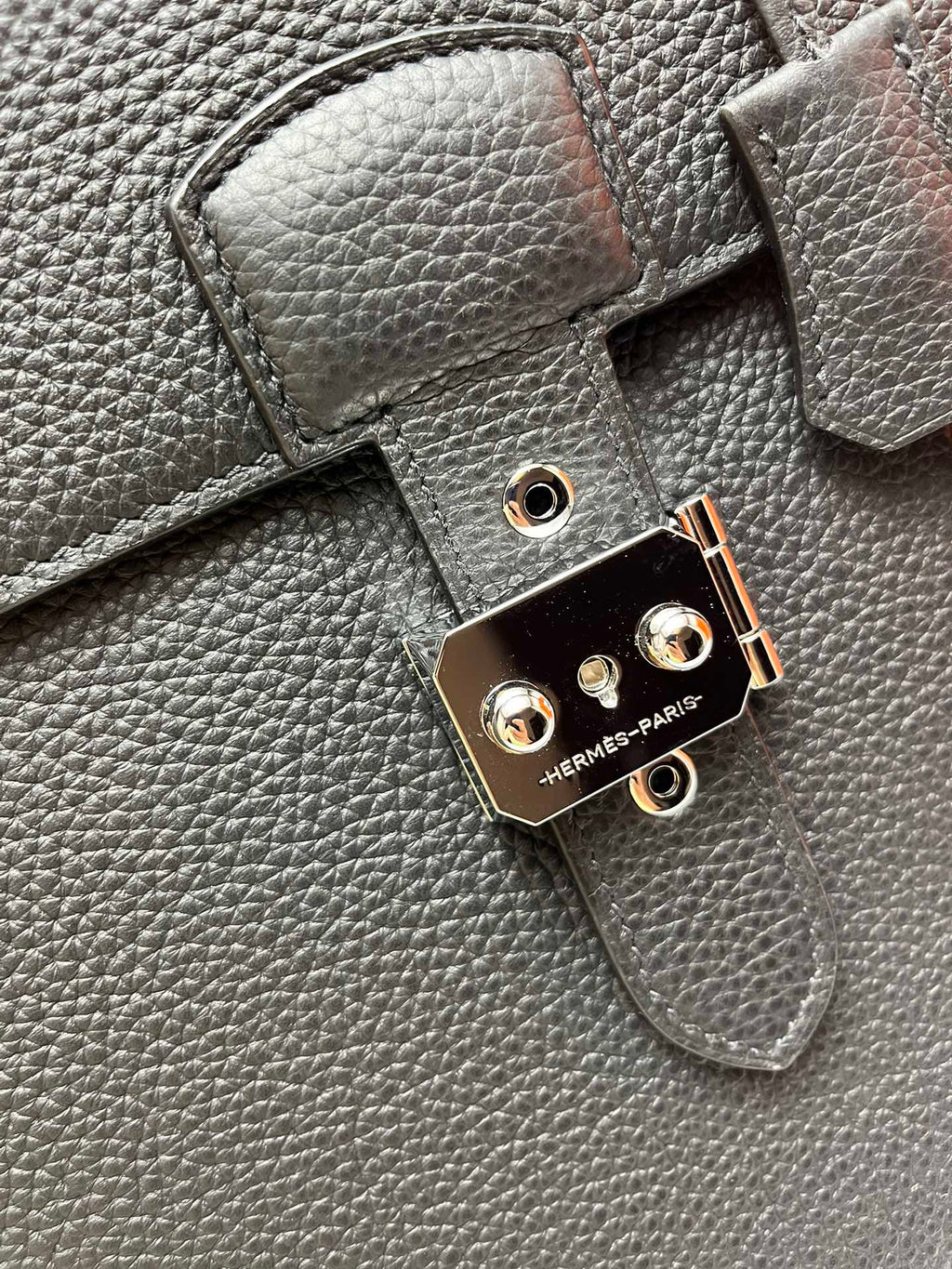 Leather satchel lock hardware with round studs and "HERMES-PARIS" mark