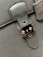 Leather satchel lock hardware with round studs and "HERMES-PARIS" mark