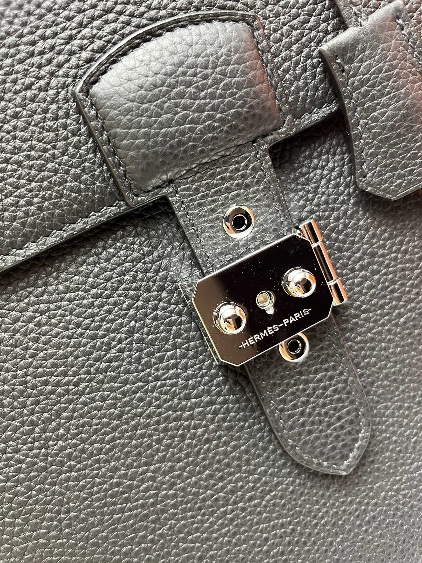 Leather satchel lock hardware with round studs and "HERMES-PARIS" mark