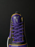 Low-top basketball shoe close-up of toe and laces, purple upper with black overlays.
