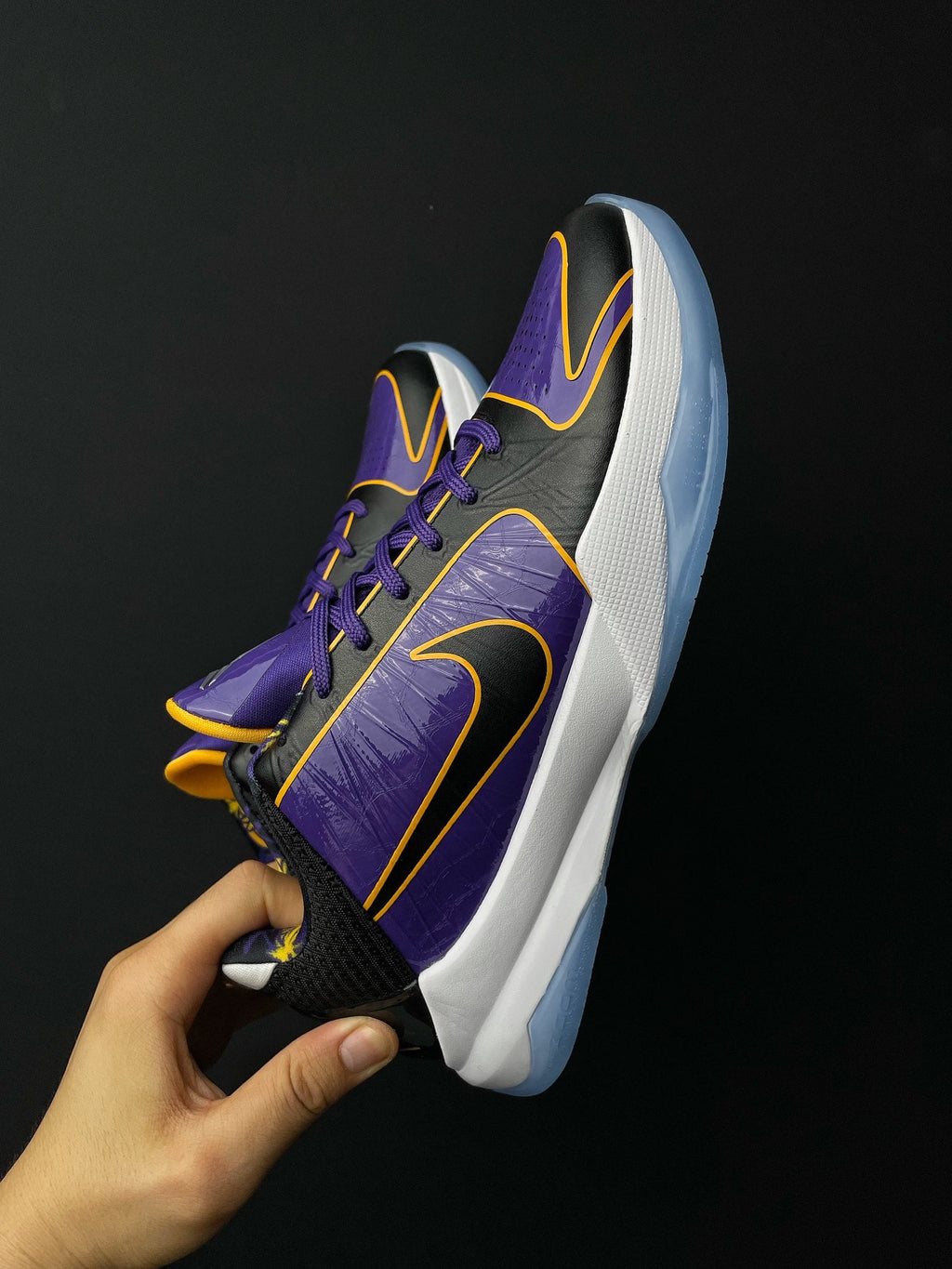 Low-top basketball shoe shown from heel side, purple upper, black accents, white midsole.
