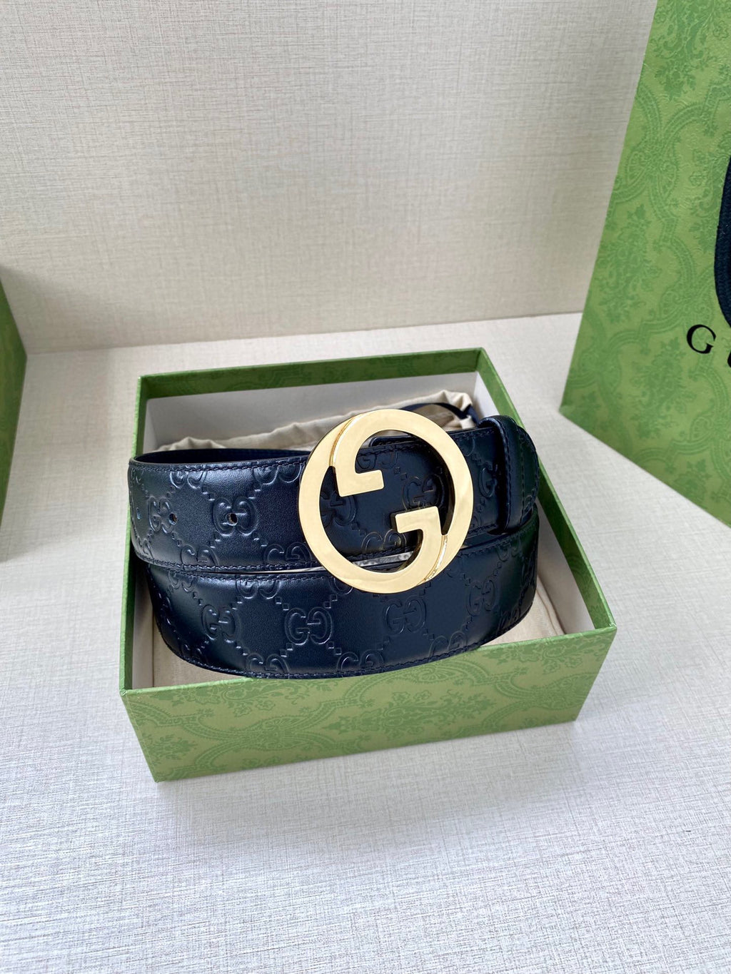 Gucci navy leather belt with embossed GG pattern and gold-tone double G buckle