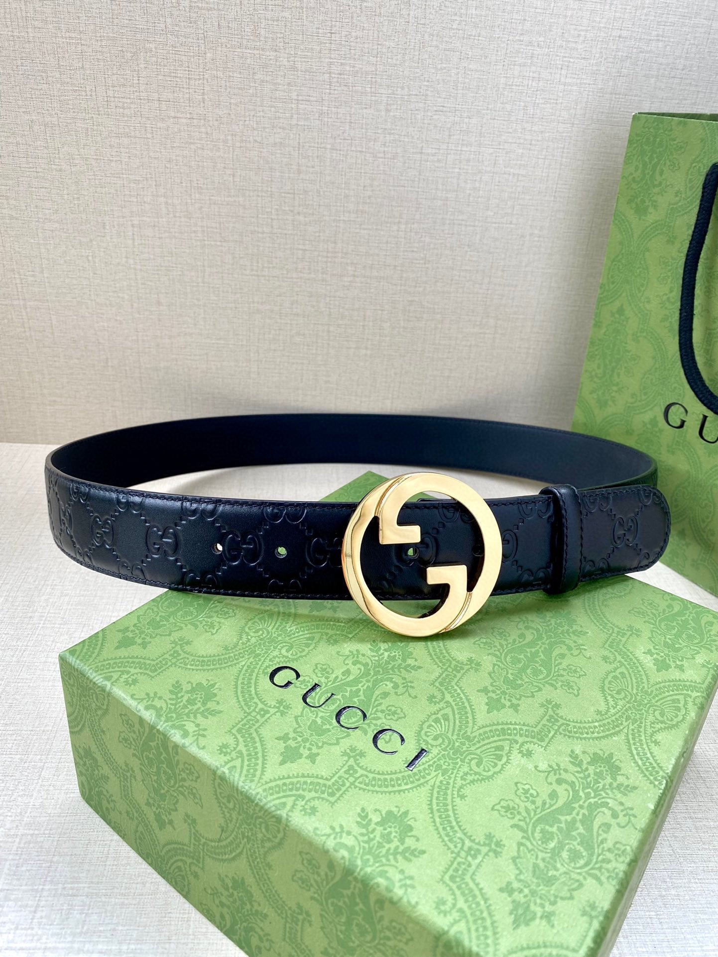 Gucci navy leather belt with embossed GG texture and gold-tone double G buckle