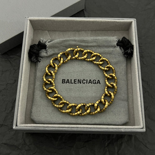 Balenciaga gold-tone chain bracelet with BALENCIAGA logo plate and black tassel ends