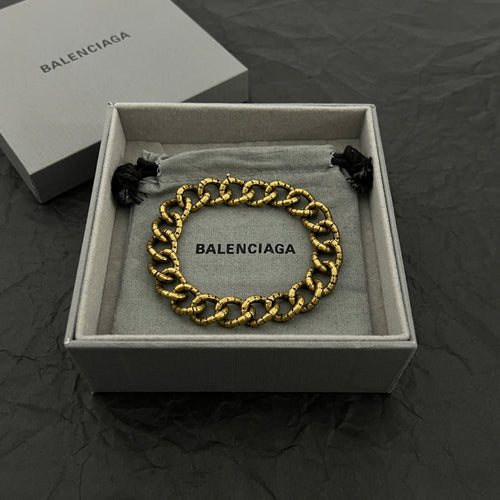 Balenciaga gold-tone chain bracelet with BALENCIAGA logo plate and black tassel ends