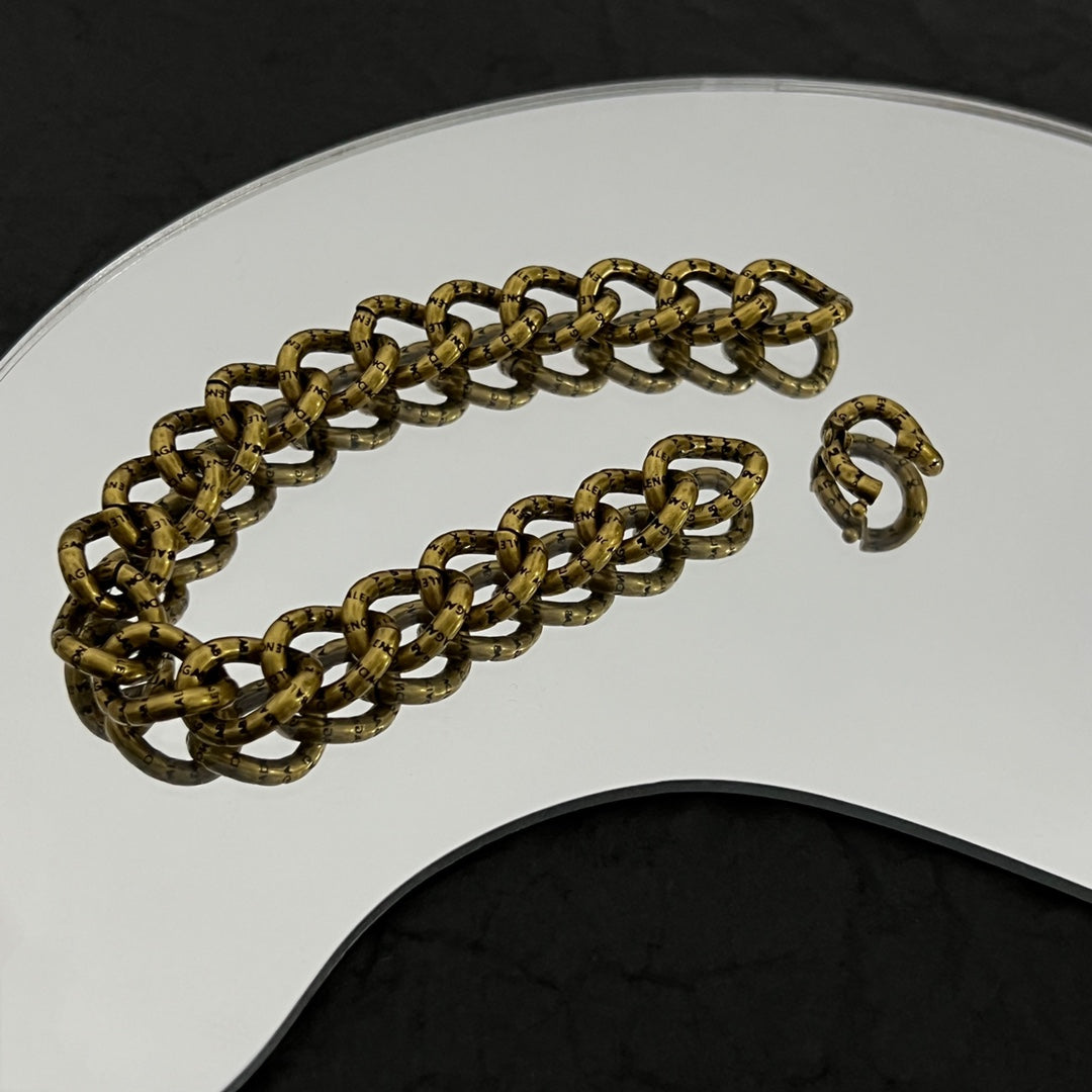 Balenciaga gold-tone chain bracelet close-up with interlocking links and clasp ring