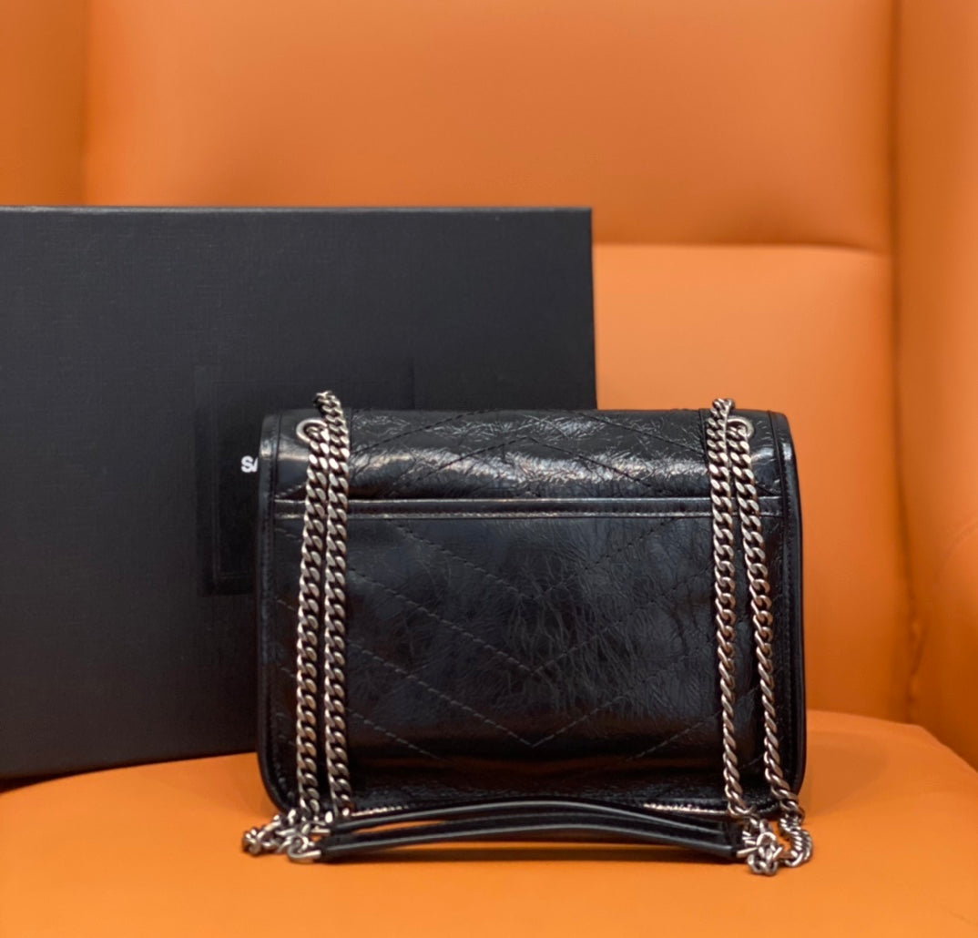 Black quilted leather shoulder bag with YSL logo, flap front, and double chain strap