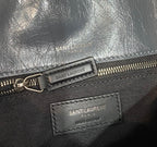 Saint Laurent zip pull and brand label on textured dark blue leather bag