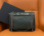 Dark green leather flap shoulder bag with chain handles and stitched panels