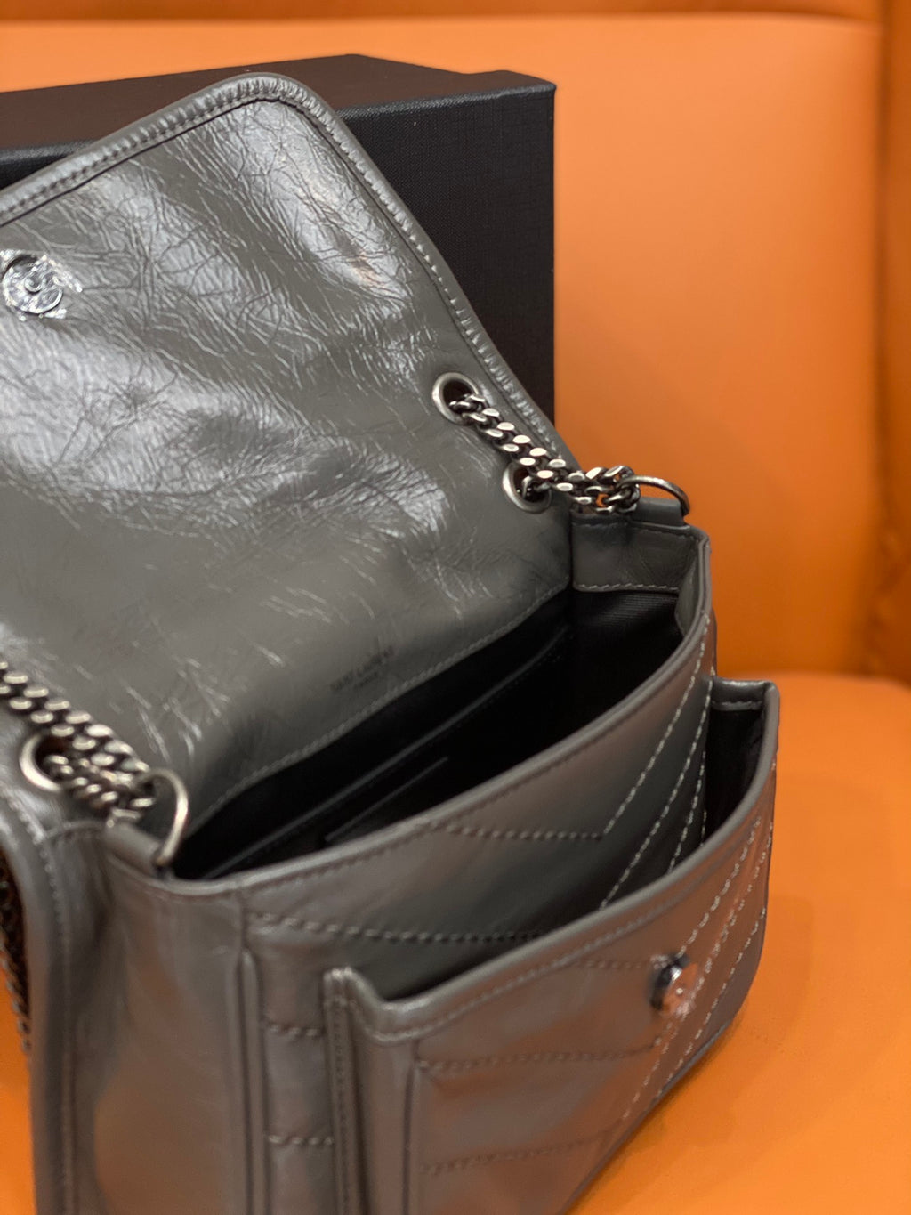 Leather shoulder bag side view with chain strap and stitched seams, medium gray