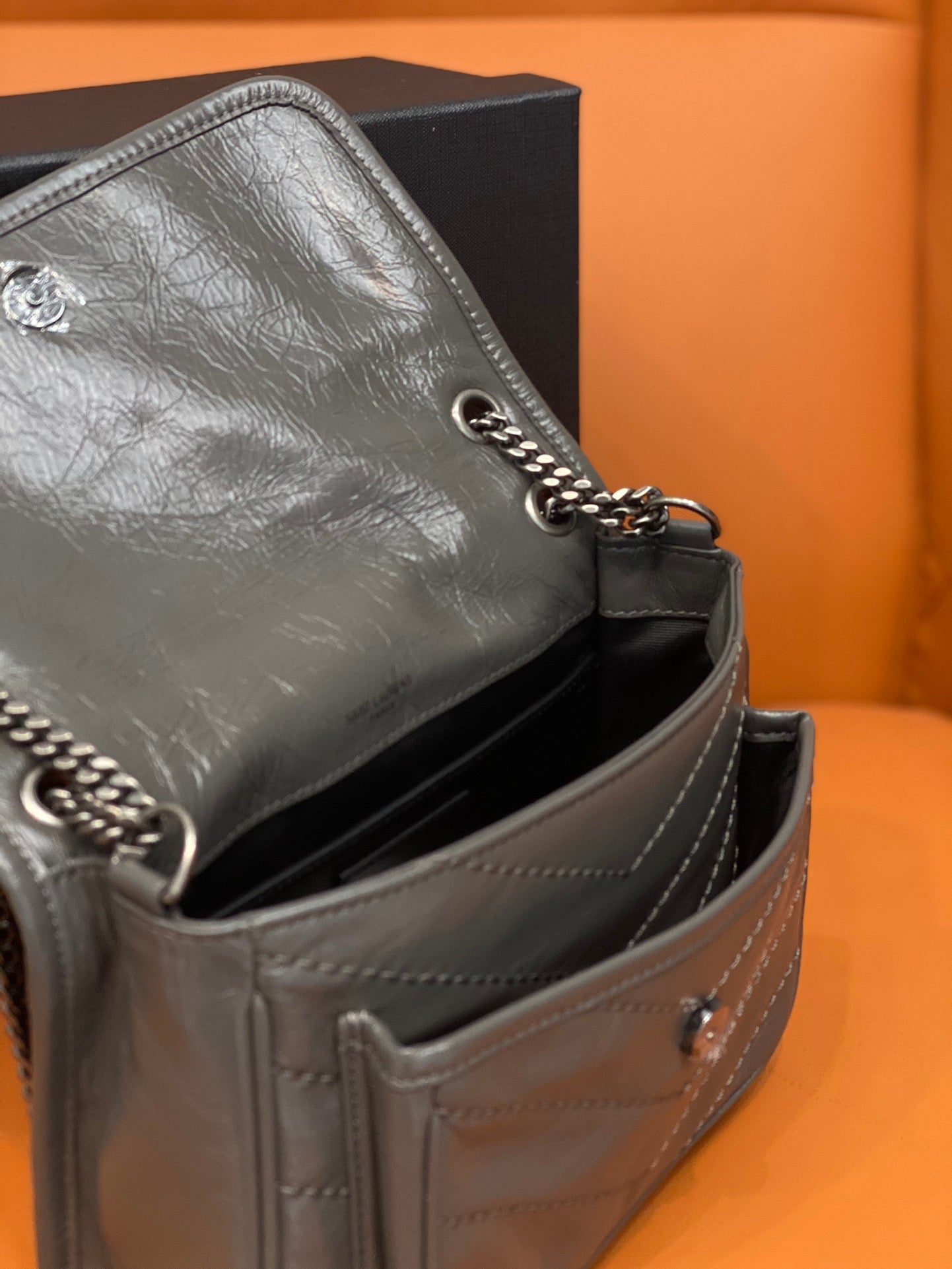 Leather shoulder bag side view with chain strap and stitched seams, medium gray