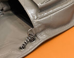 Metallic gray shoulder bag with chain links and side pocket seam detail