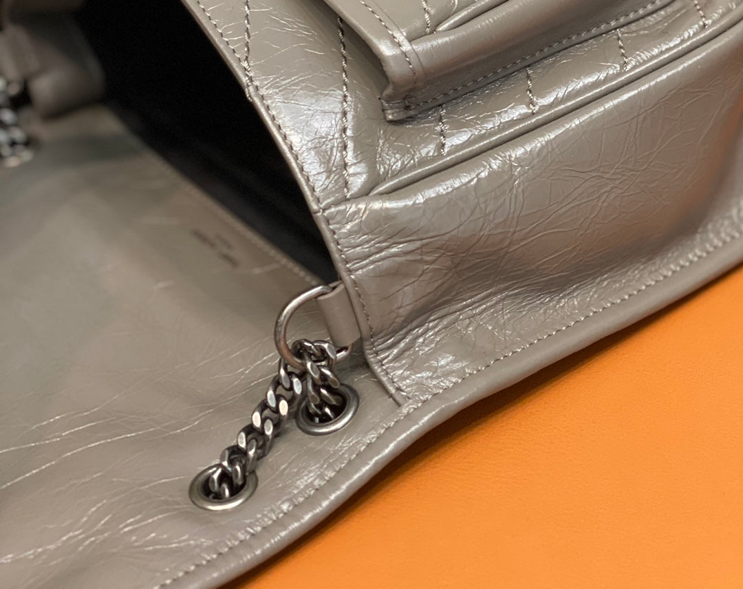 Metallic gray shoulder bag with chain links and side pocket seam detail
