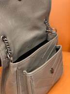 Small metallic gray shoulder bag with open interior, front stitching, and chain strap