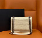Cream quilted crossbody bag with flap closure and silver chain straps.