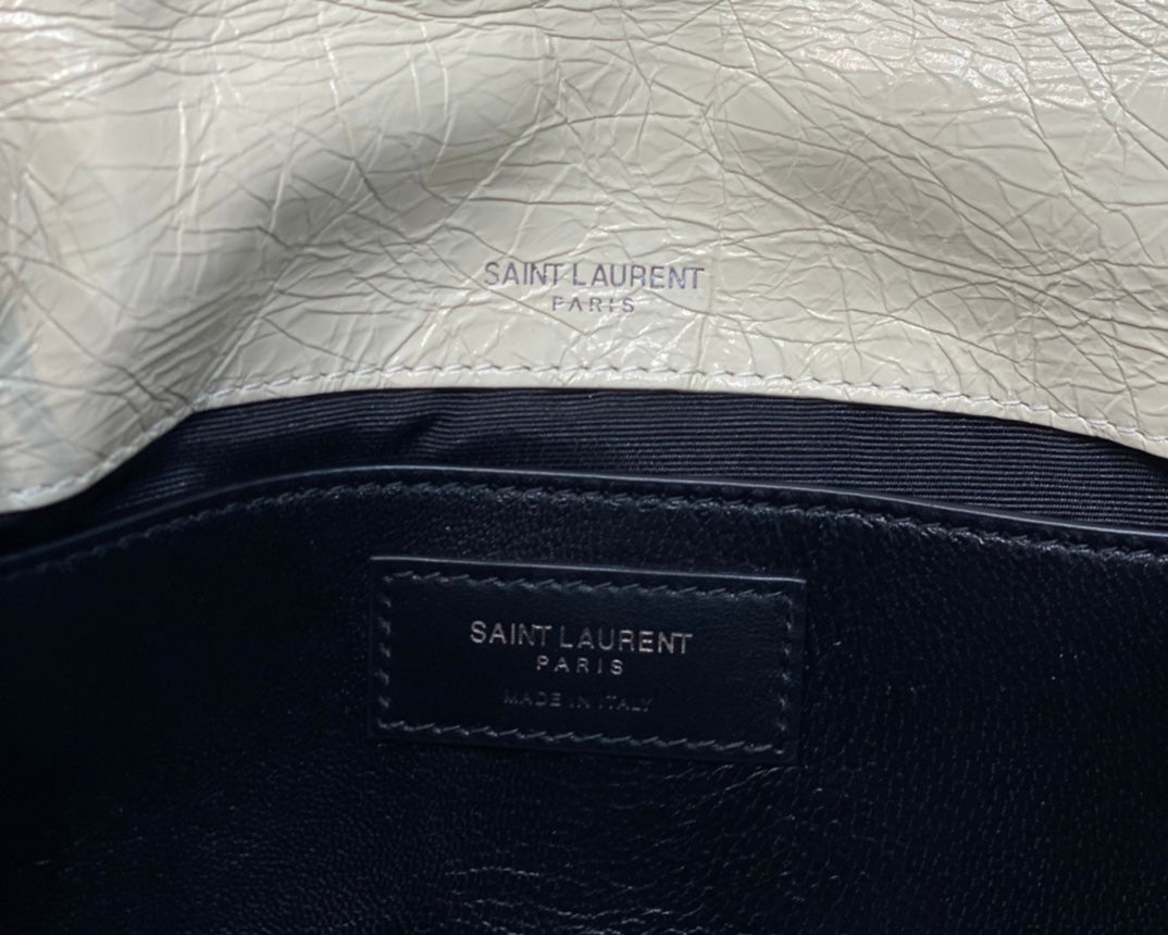 Cream leather lining with Saint Laurent Paris stamp on inner panel and strap.