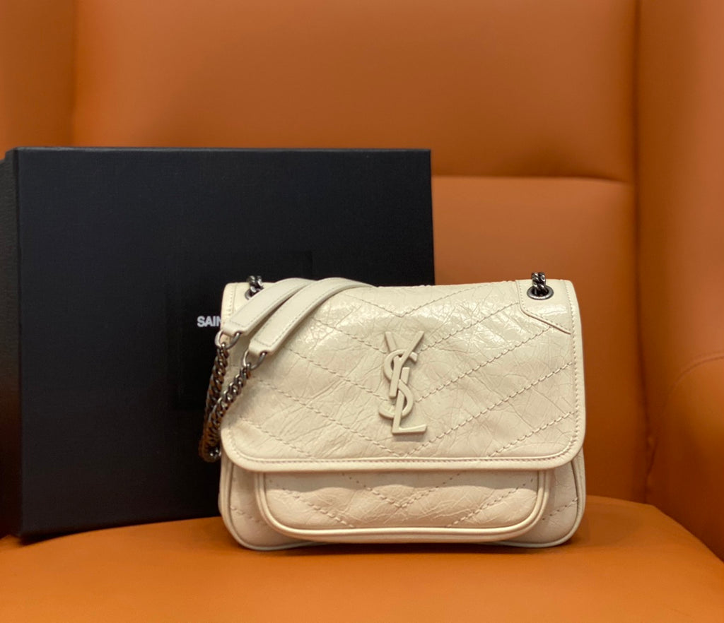 Cream quilted leather shoulder bag with flap and YSL-style logo, chain strap.