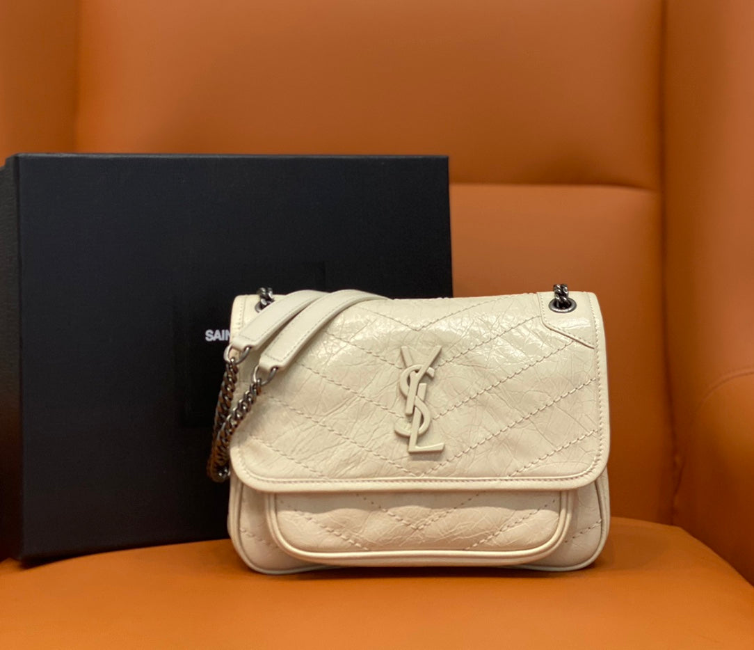 Cream quilted leather shoulder bag with flap and YSL-style logo, chain strap.
