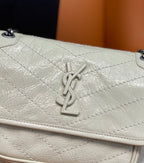 Cream textured leather flap detail with YSL-style monogram and stitched quilting.