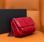 Red shoulder bag with chain strap, quilted flap and side view