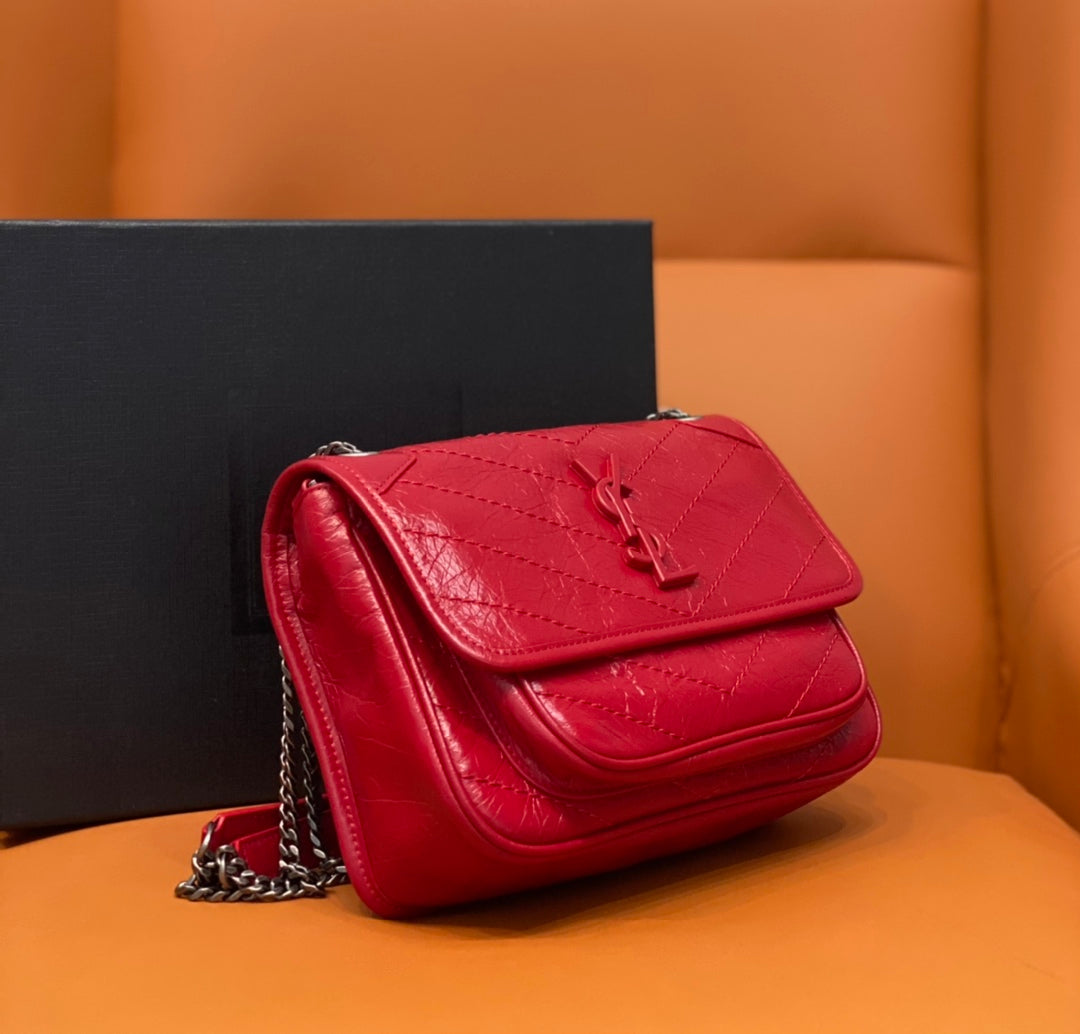 Red shoulder bag with chain strap, quilted flap and side view