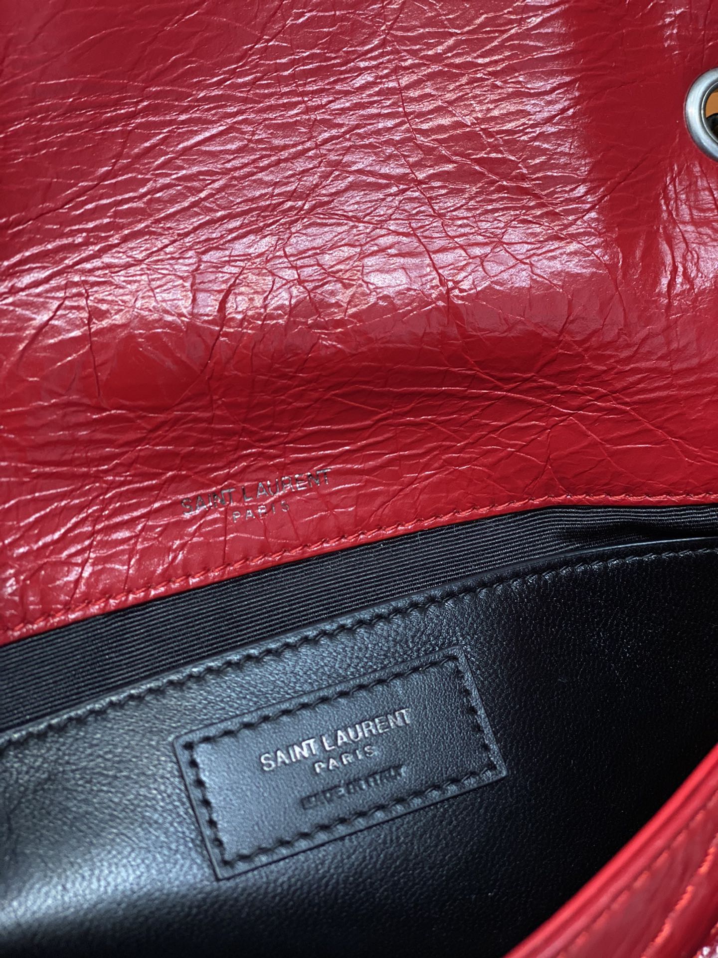 Black leather patch with Saint Laurent Paris text on red bag