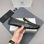 Versace black leather loafer shoe side view with gold medallion and contrast white stitching